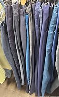 Row of assorted navy women’s pants on hangers