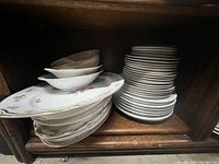 Stacked plates and trays showing floral patterns and metallic edges
