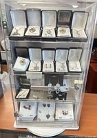 Front view of acrylic case showing boxed jewelry on three shelves
