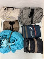 Six rolled/bagged air mattresses laid out