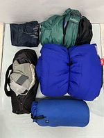 Overview of all packed items: three sleeping bags, tent bag, pillow sack