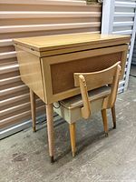 Closed sewing cabinet with stool nested underneath