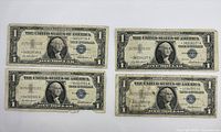 Front view of all four 1957A silver certificates showing serial numbers and wear