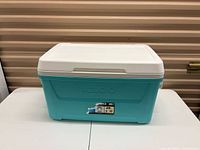 Front view of turquoise Igloo cooler with white lid
