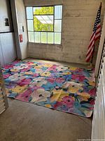 Rug spread on floor showing overall floral design and size relative to room