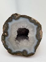 Front view showing full cut face with agate banding and quartz cavity