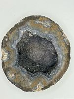 Front view of gray druzy agate half showing crystal cavity and agate banding