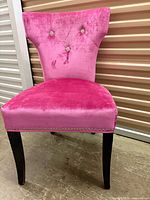 Front view showing pink upholstery, rhinestone buttons, nailhead trim, dark legs