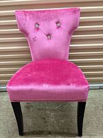 Front view of pink velvet dining chair showing tufted back, seat, legs