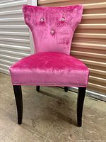 Front view of chair showing upholstery, tufting and legs