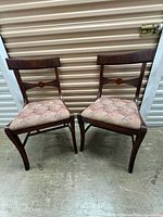 Front view of both mahogany chairs displaying upholstery and back splats