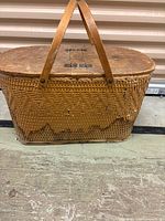 Front view of wicker picnic basket with handles up
