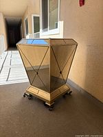 Front view of mirrored champagne gilt table base on casters
