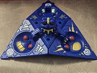 Front view of blue triangular Bakugan trap, hinges visible