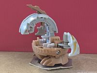 Left side view of Bakugan Naga Dragonoid D2 in open form on hexagonal plate