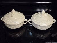 Two identical covered soup bowls with lids shown on stovetop