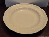 Top view of cream colored Gien cake plate showing textured border and condition