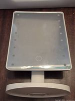 Mirror out of packaging showing LED layout, touch button, stand and base