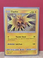 Front of the sleeved Zapdos SM145 cosmos holo card