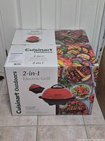 Front view of sealed retail box showing Cuisinart Outdoors 2-in-1 Electric Grill image and branding