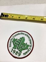Full view of embroidered patch with tape measure showing roughly 3 in diameter