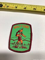 Front view of Wolf Cubs patch with tape measure showing size