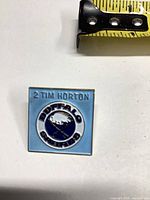 Front view showing Sabres logo and Tim Horton text with tape measure for scale