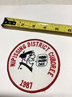 Front of round embroidered patch with measuring tape showing approximately 5-in diameter