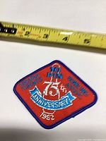Front view of embroidered patch with measuring tape showing size