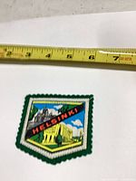 Front view of Helsinki embroidered patch beside tape measure showing size
