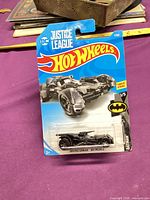 Front of carded Hot Wheels Justice League Batmobile showing blister, graphics, age rating, Batman logo