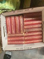 Box containing multiple red Whitaker's Almanack hardcovers stacked with spines visible