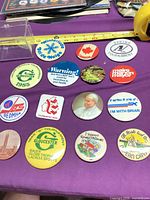 Overview of all 15 pinback buttons with measuring tape for scale
