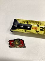 Front of enamel Ottawa Grey Cup CFL lapel pin beside ruler