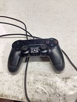 Front view of DualShock 4 controller showing buttons and cable