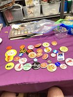 Overall view of all 24 vintage buttons laid out on table