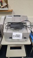 Front and top view of fax machine showing overall condition and accessories