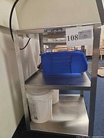 Full view of stainless cart showing three shelves and casters