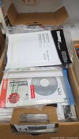 Stack of manuals and discs in box, visible Danby Designer manual