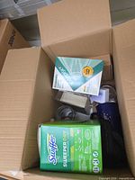 Overview of lot in box showing Swiffer, Kaspersky, mug and jar