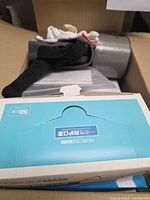 Box of masks, gloves box, candle partially visible in carton
