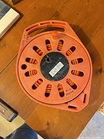 Top view of orange extension cord wound on plastic reel
