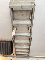 Full view of folded aluminum ladder showing 7 steps and platform