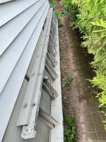 Full length view of ladder stored on side of house