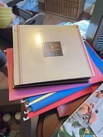 Stack of albums and hanging folders showing colors and hooks