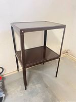 Full view of brown metal 2-tier side table angled