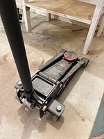 Full view of hydraulic floor jack with handle attached