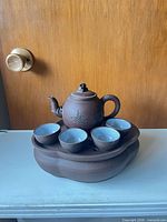 Full view of teapot set assembled on tray with cups
