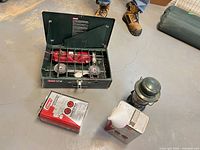 Entire lot showing stove open, lantern, fuel can and funnel