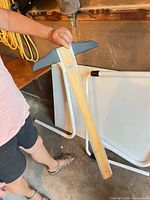 Wooden drafting T-square with grey plastic head held in hand